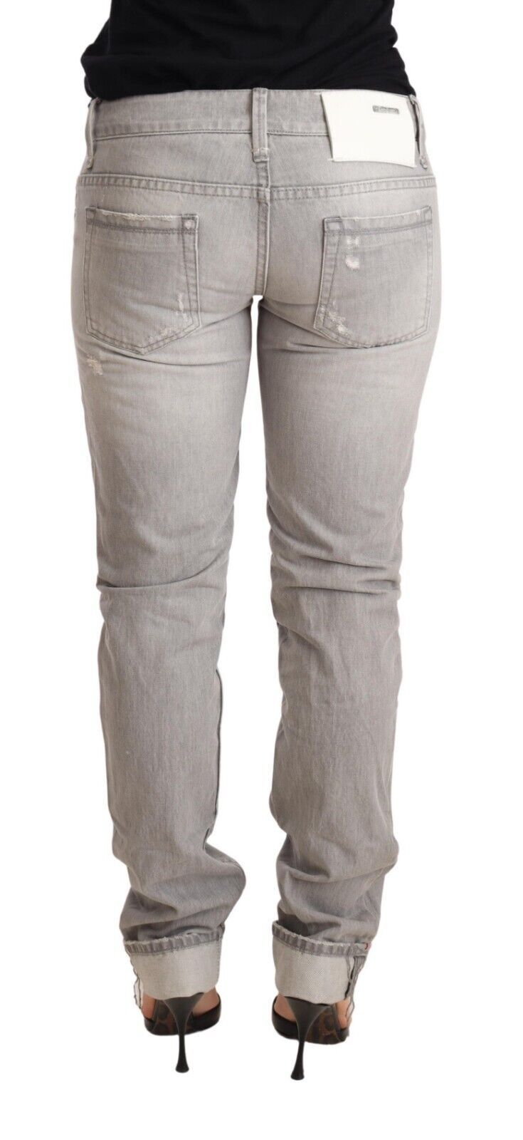Acht grijze, versleten, smalle katoenen jeans voor dames met opgerolde pijpen.