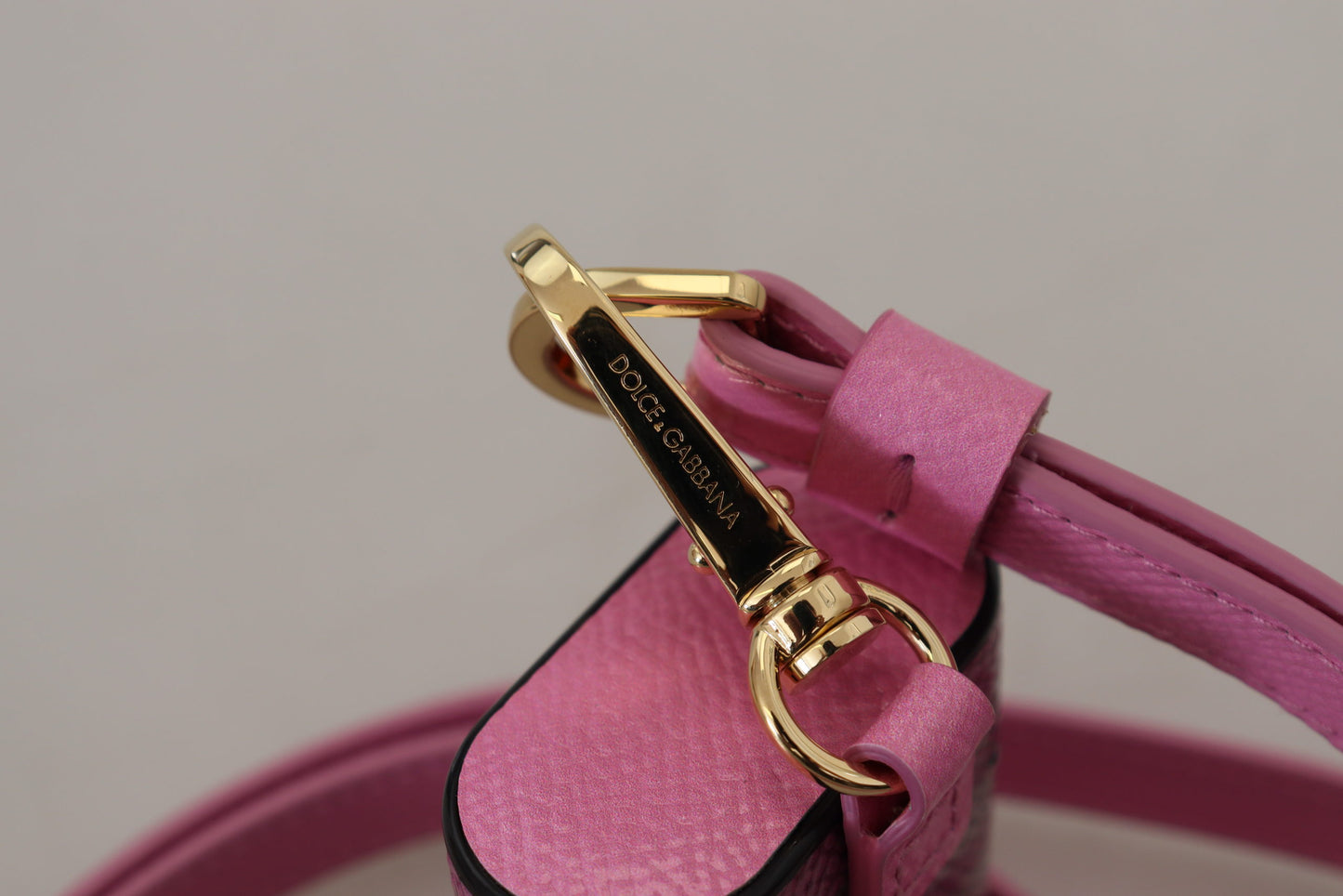 Étui pour Airpods Dolce & Gabbana avec bracelet en cuir rose et noir et logo en métal doré