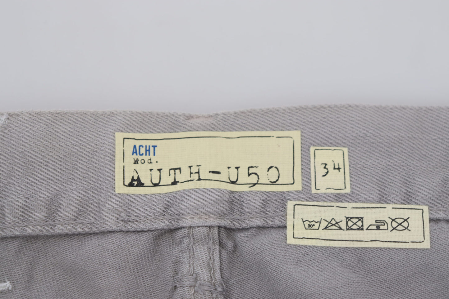 Acht grijze katoenen, rechte, casual jeans met opgevouwen zoom.