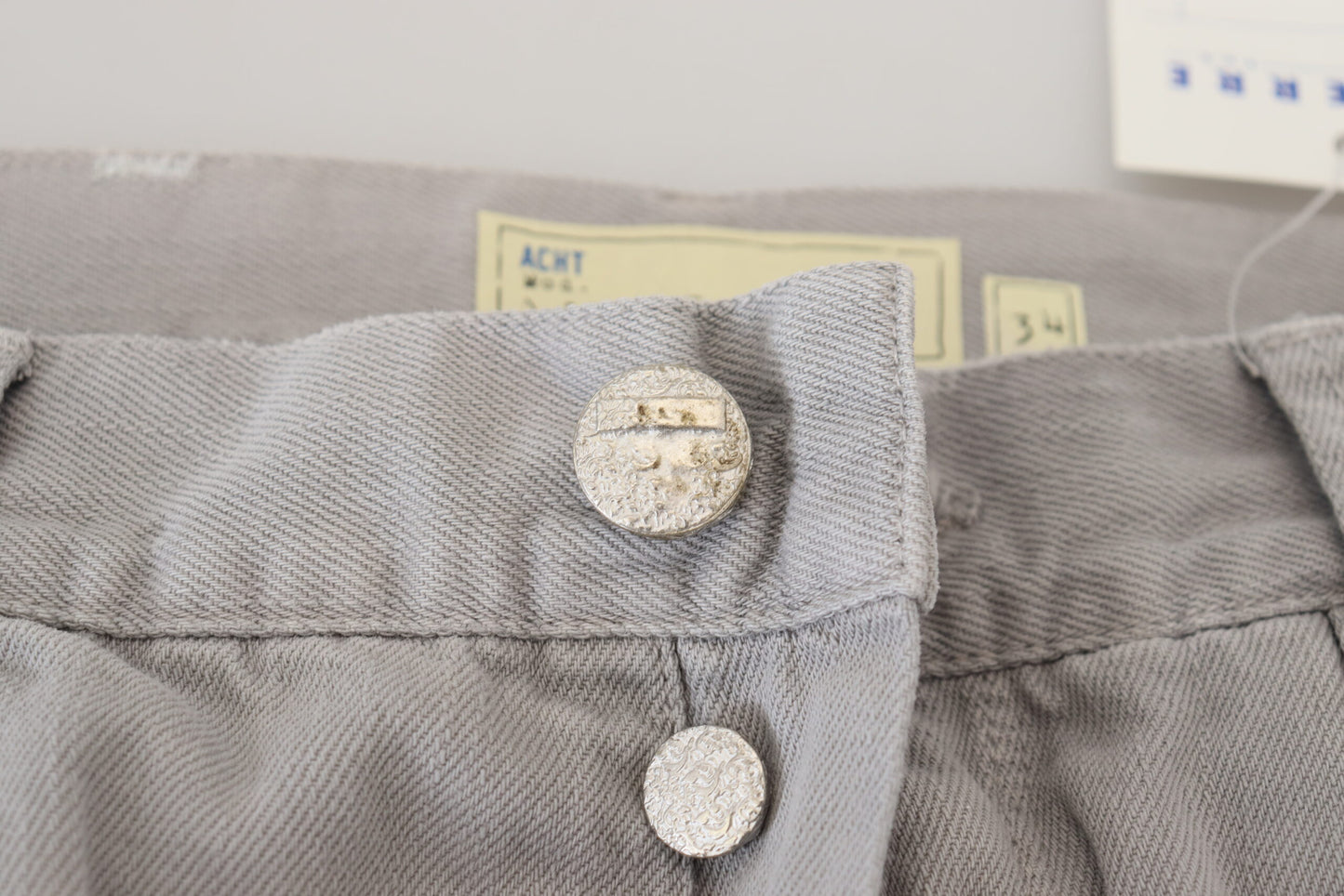 Acht grijze katoenen, rechte, casual jeans met opgevouwen zoom.