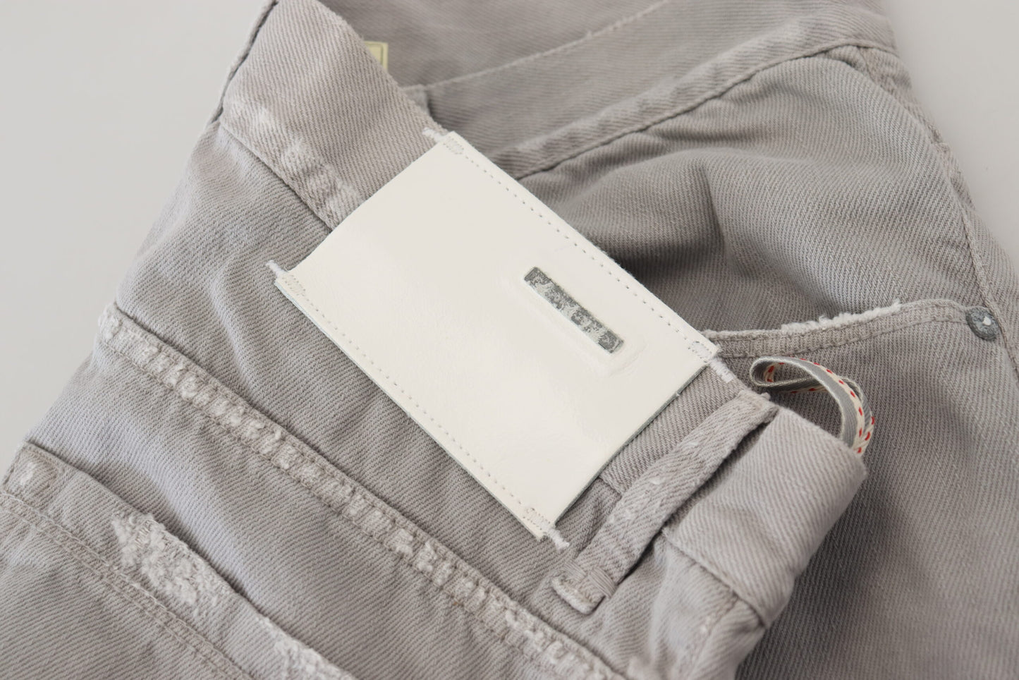 Acht grijze katoenen, rechte, casual jeans met opgevouwen zoom.