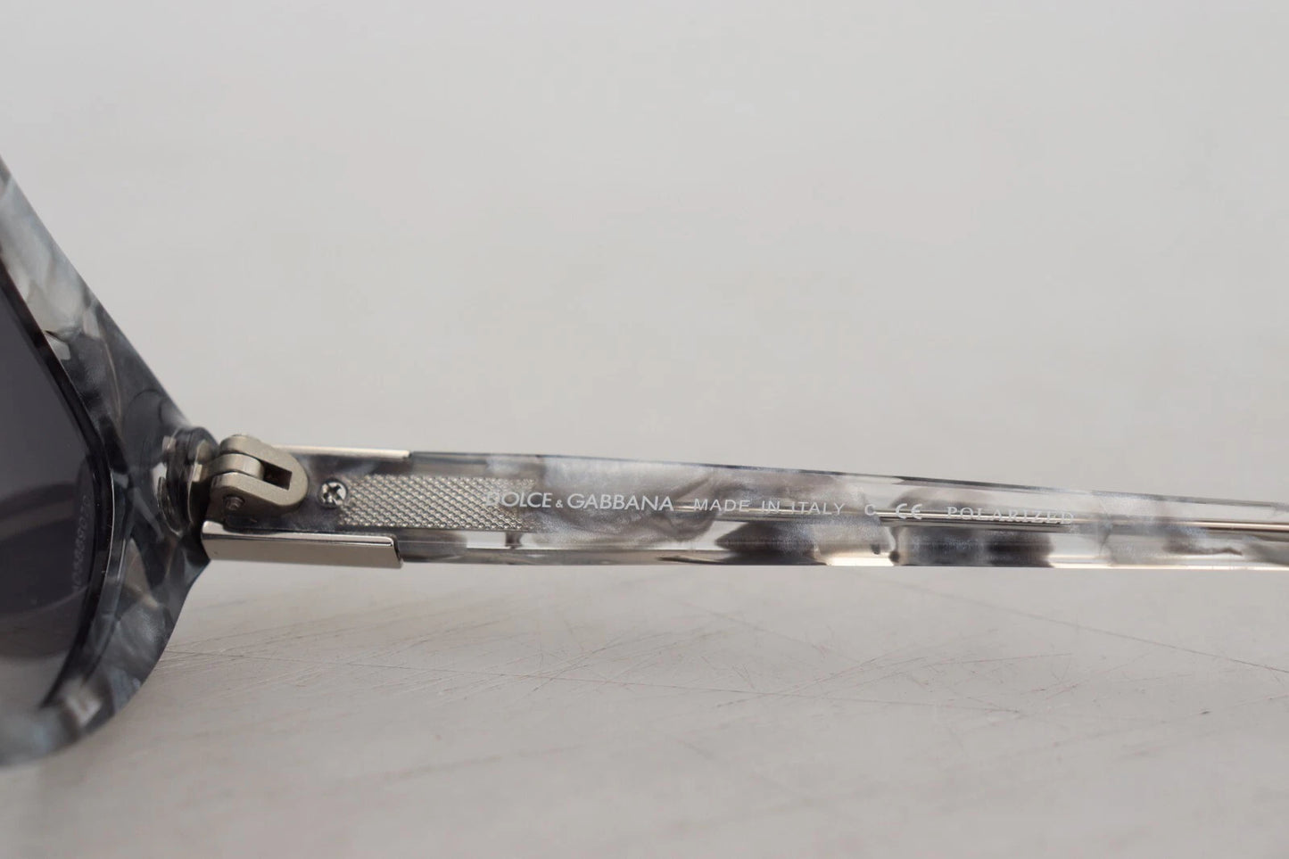 Lunettes de soleil Dolce & Gabbana DG4194, forme œil de chat, en acétate gris, avec plaque logo.