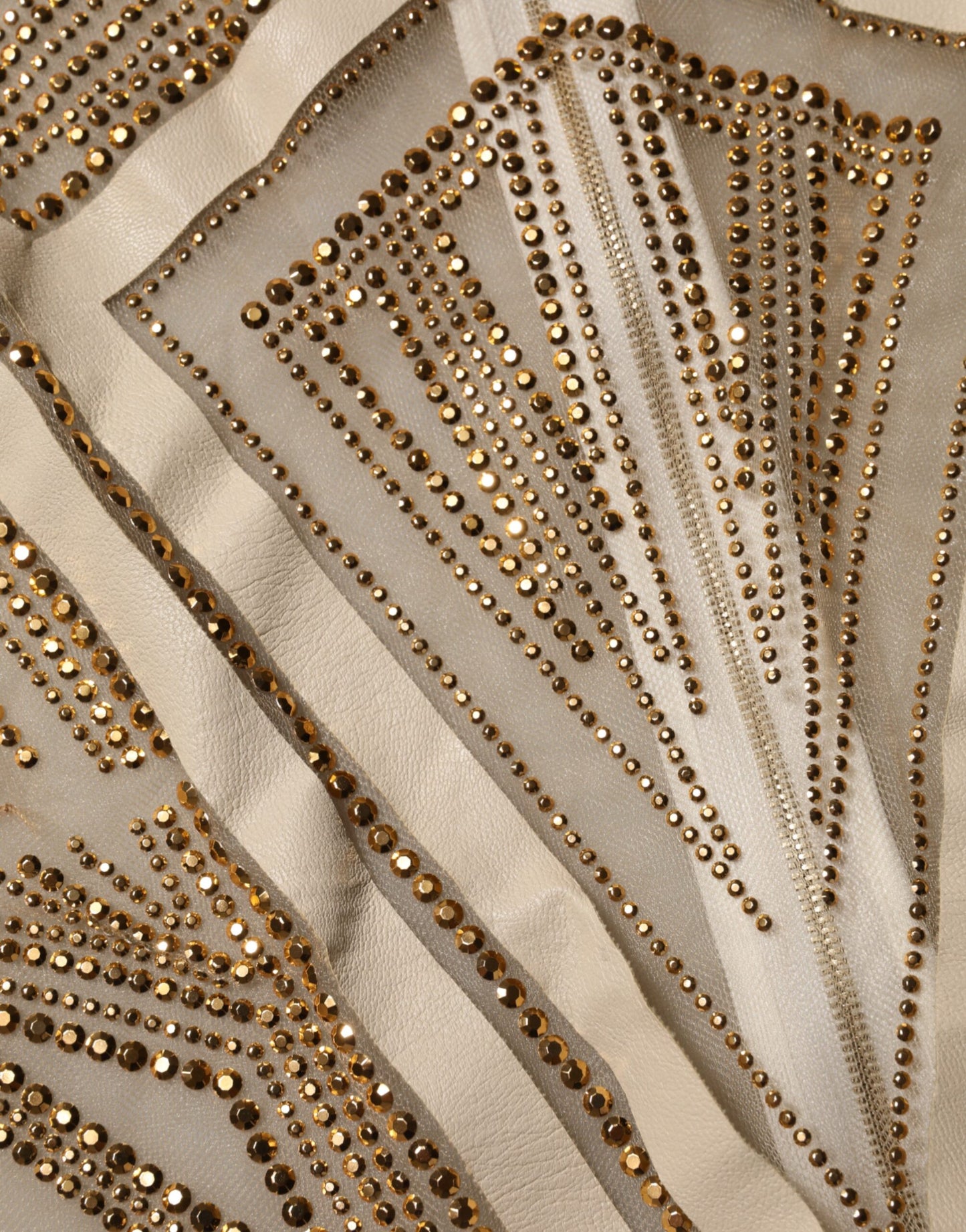 Jumpsuit sans manches Mangano en tulle beige clair, ornée de cristaux.