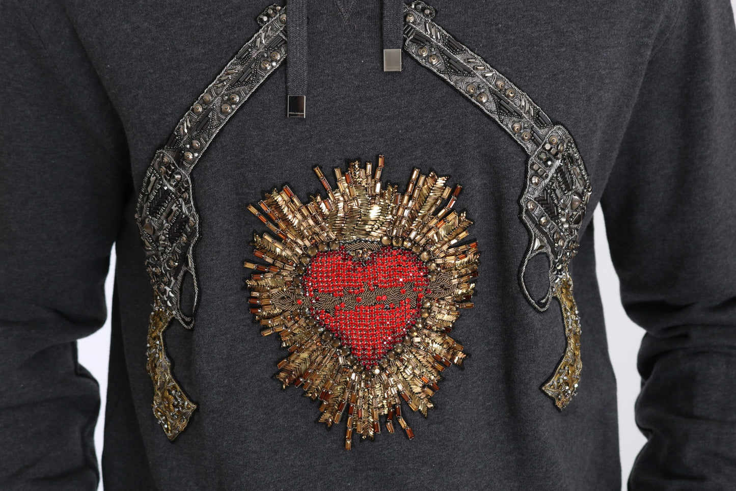 Pull gris à capuche Dolce & Gabbana avec cœur rouge en cristal et motif pistolet.