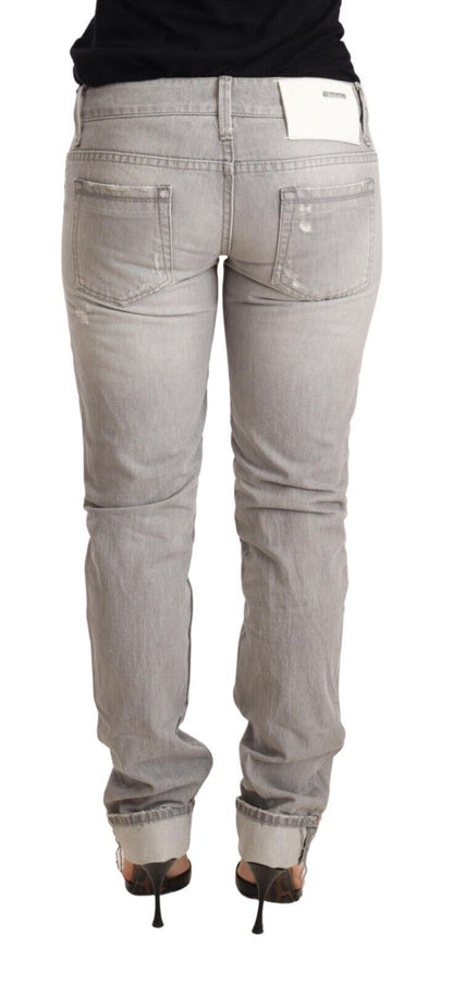 Acht grijze, versleten, smalle katoenen jeans voor dames met opgerolde pijpen.