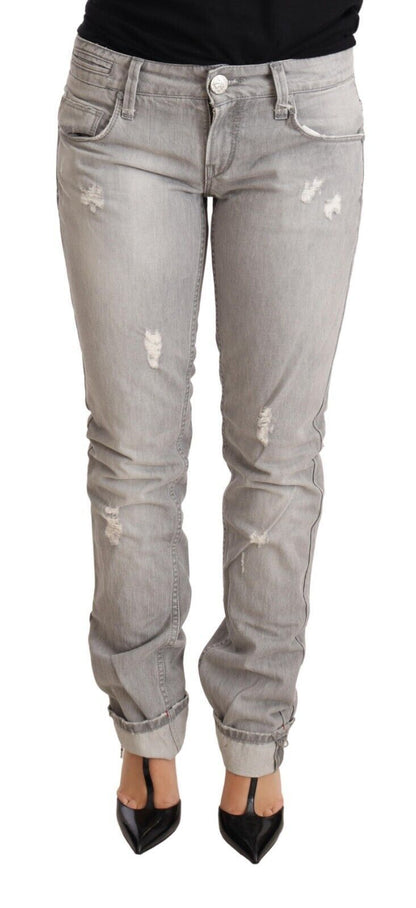 Acht grijze, versleten, smalle katoenen jeans voor dames met opgerolde pijpen.