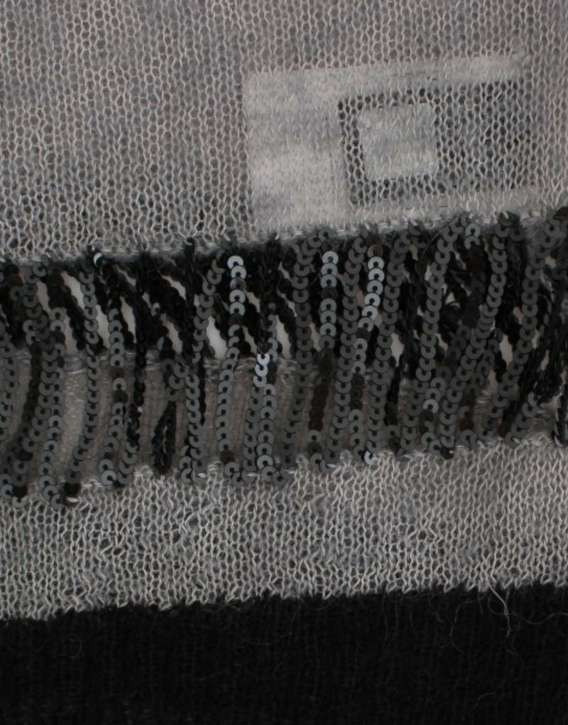 Costume National, pull asymétrique gris avec ornements.