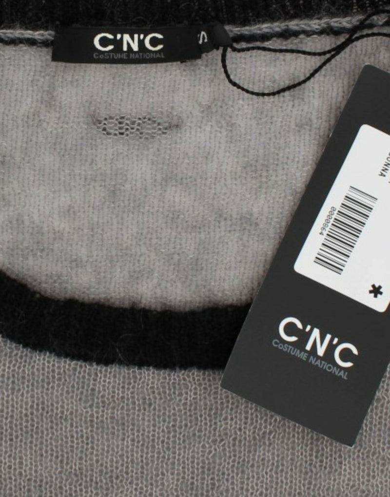 Costume National, pull asymétrique gris avec ornements.