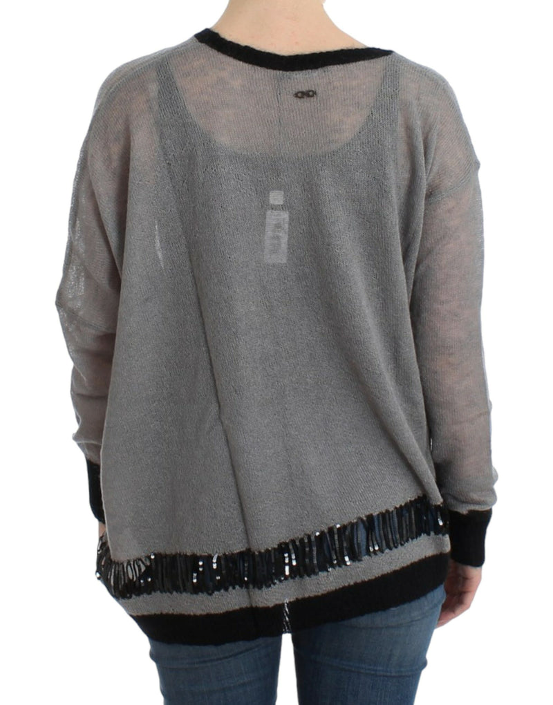 Costume National, pull asymétrique gris avec ornements.