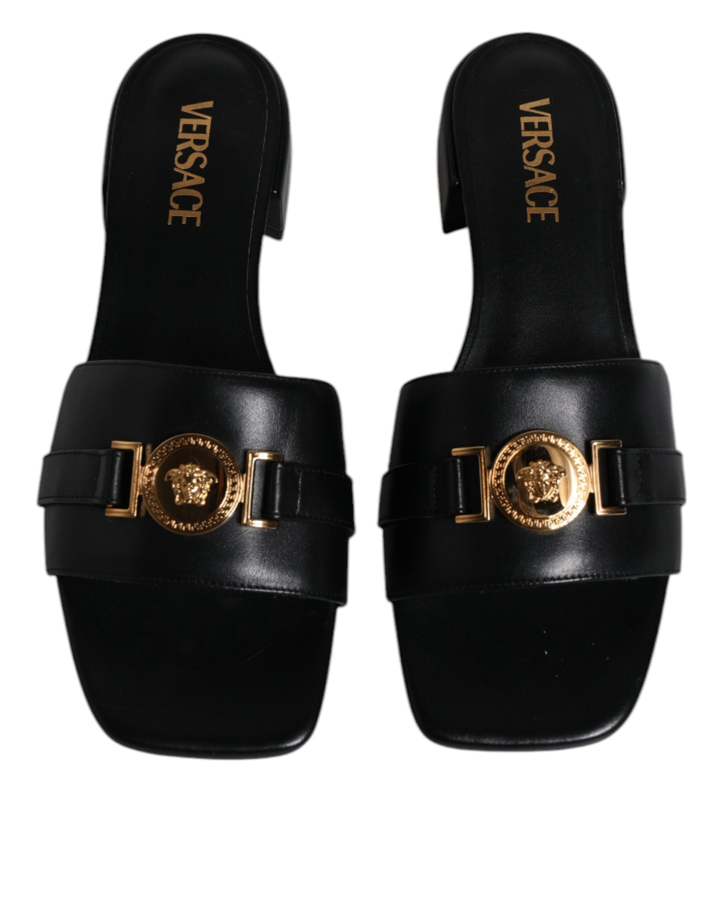 Sandales plates à enfiler en cuir noir avec plaque logo Versace.