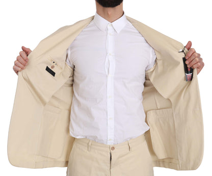 Costume deux pièces en coton beige uni, à trois boutons, de Romeo Gigli.