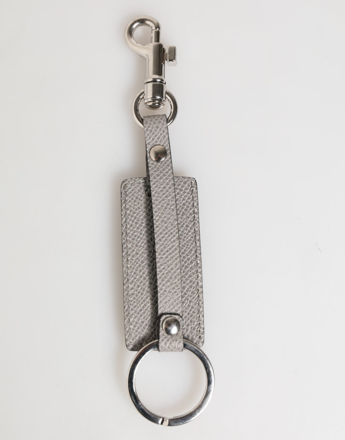 Porte-clés homme Dolce &amp; Gabbana en cuir gris avec anneau métallique et logo.
