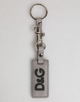 Porte-clés homme Dolce &amp; Gabbana en cuir gris avec anneau métallique et logo.