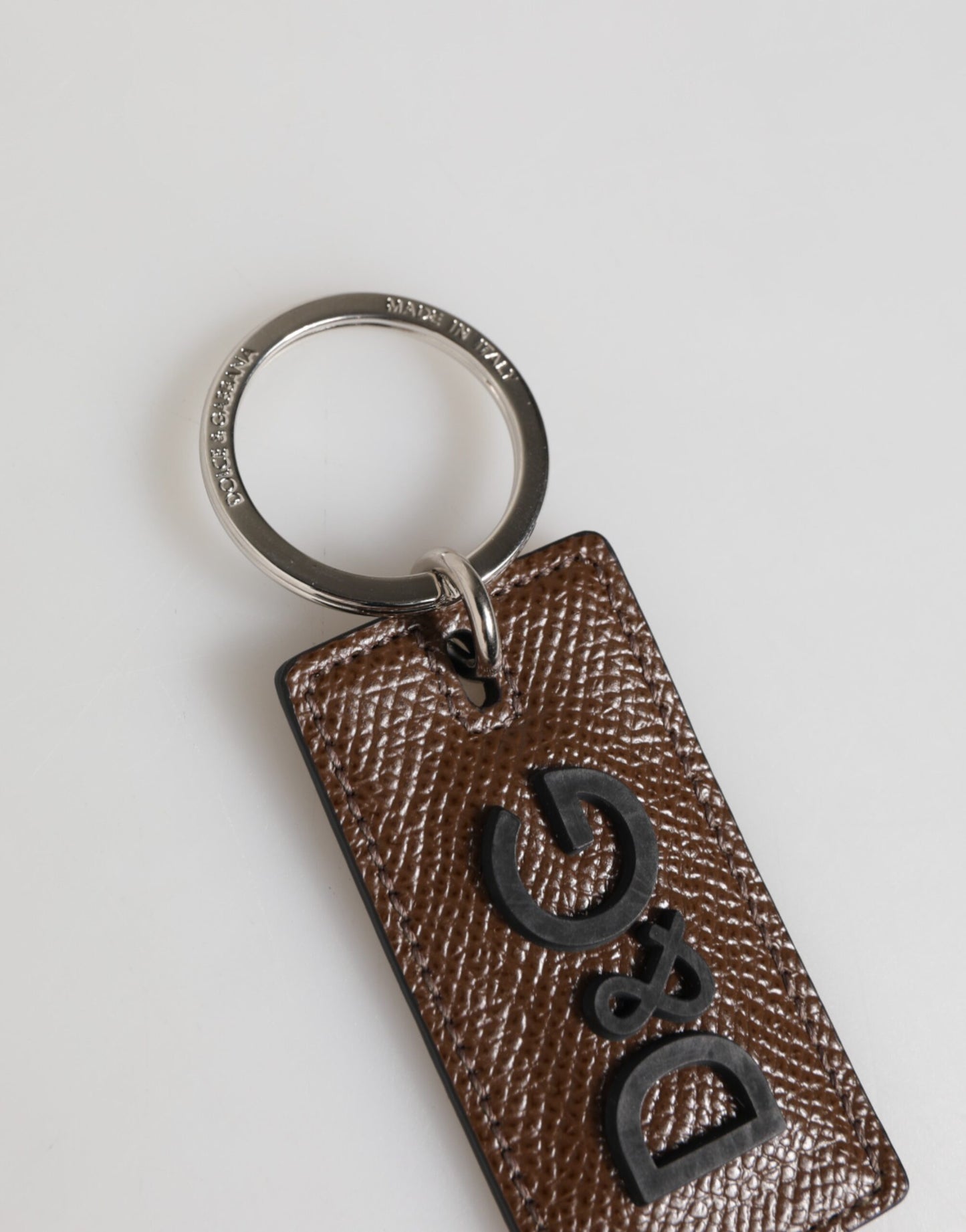 Porte-clés Dolce &amp; Gabbana en cuir marron foncé avec anneau métallique et logo.