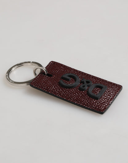 Porte-clés homme Dolce &amp; Gabbana en cuir marron foncé avec logo et anneau en métal.