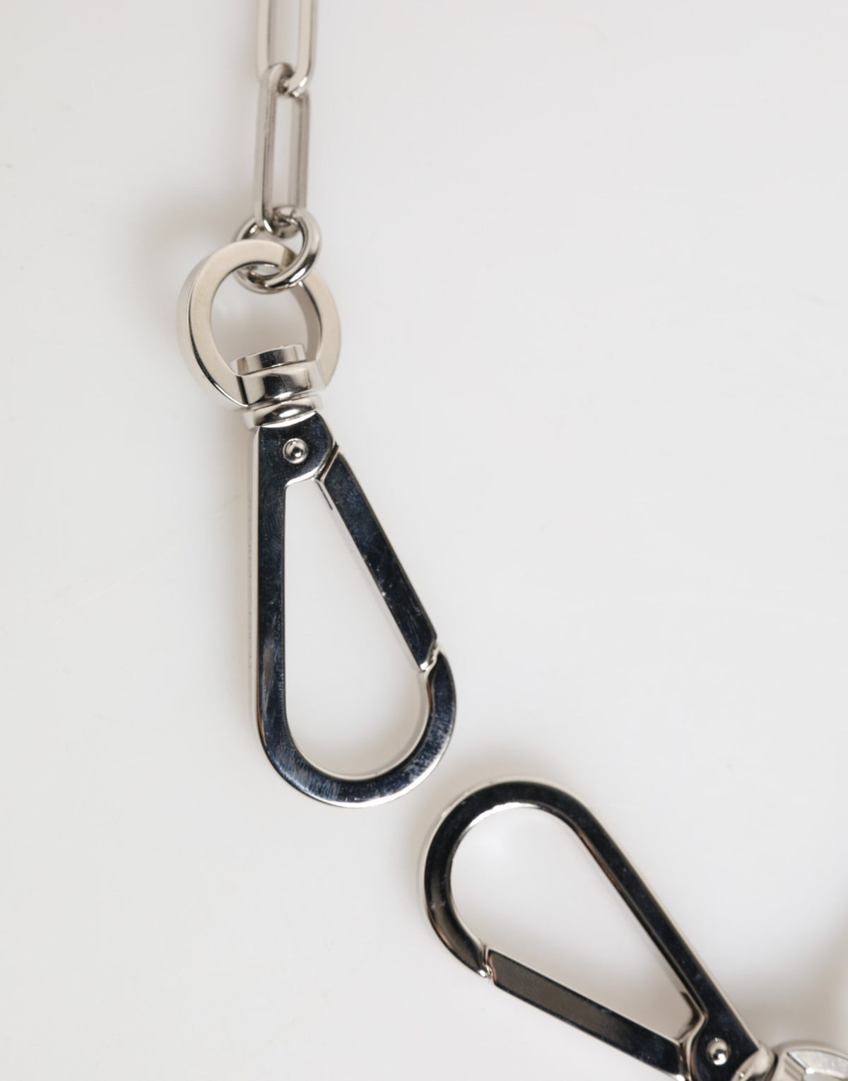Collier homme Dolce & Gabbana avec pendentif logo DG en chaîne métallique argentée.