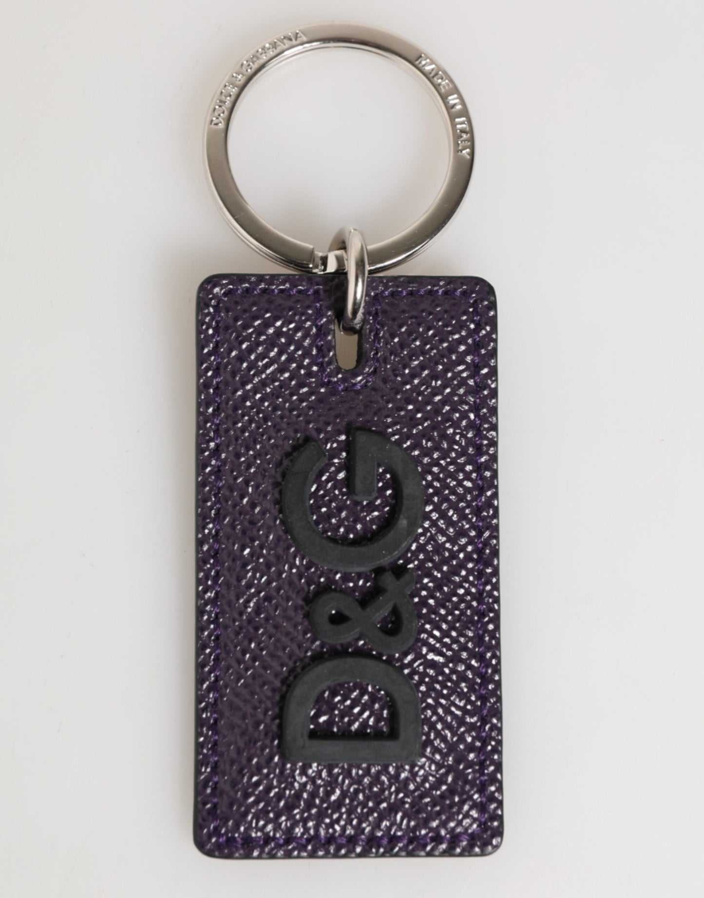 Porte-clés homme Dolce &amp; Gabbana en cuir violet avec logo métallique et anneau.