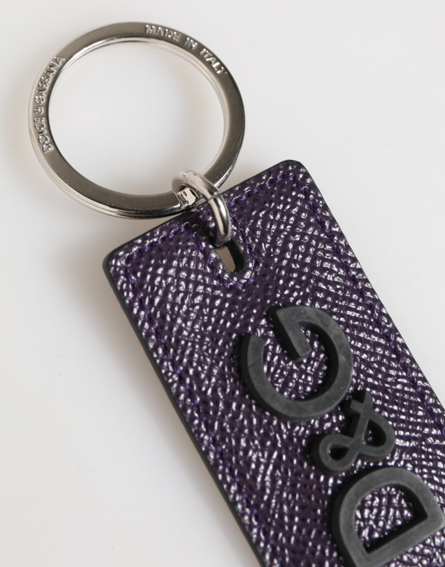 Porte-clés homme Dolce &amp; Gabbana en cuir violet avec logo métallique et anneau.