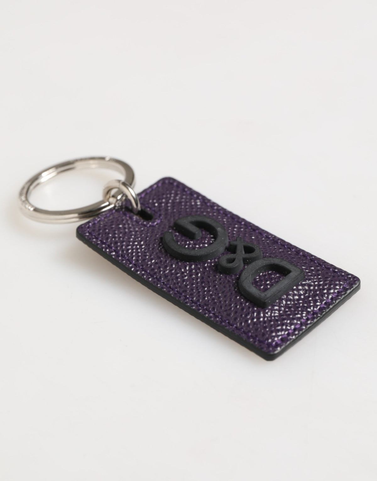 Porte-clés homme Dolce &amp; Gabbana en cuir violet avec logo métallique et anneau.