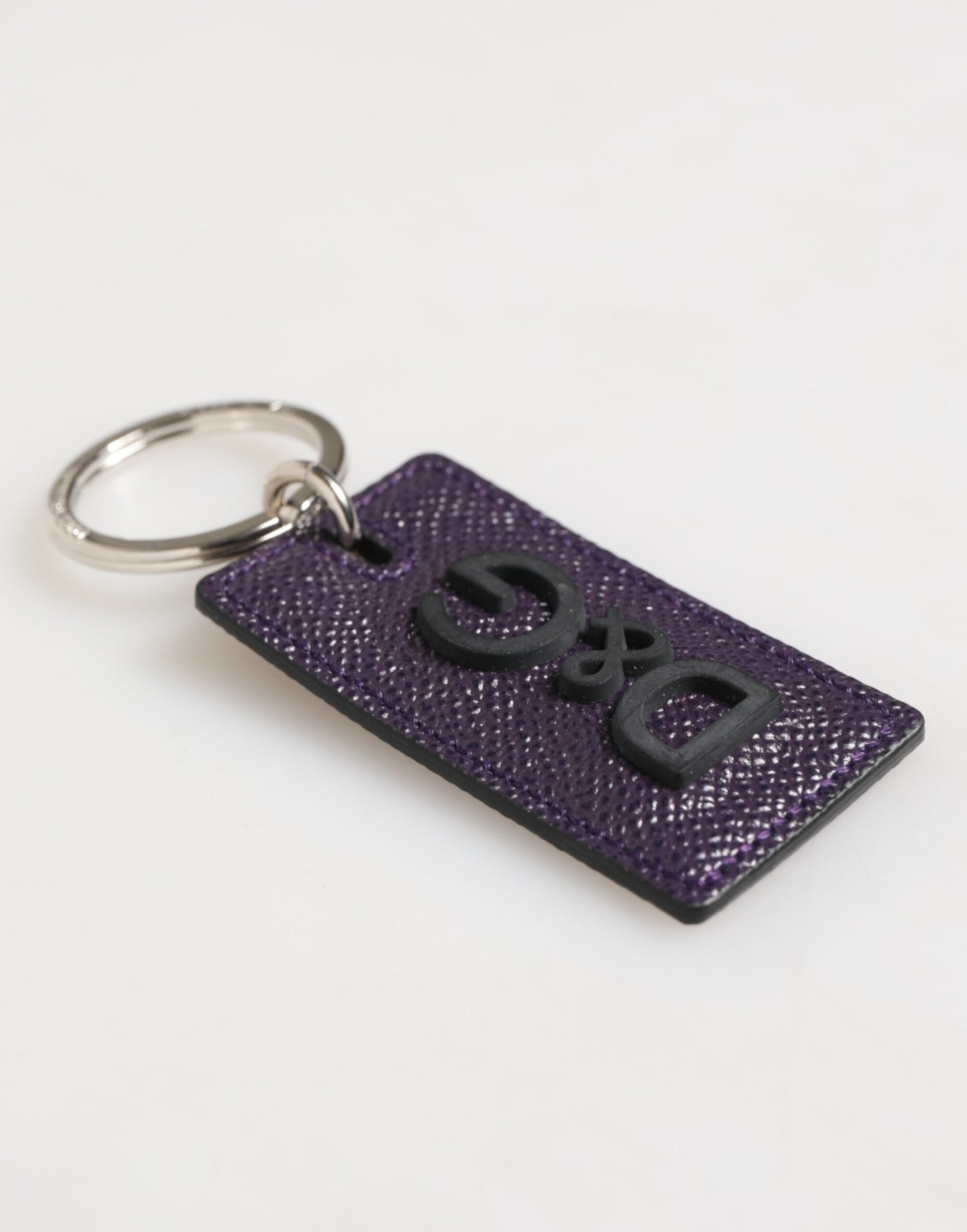 Porte-clés homme Dolce &amp; Gabbana en cuir violet avec logo métallique et anneau.