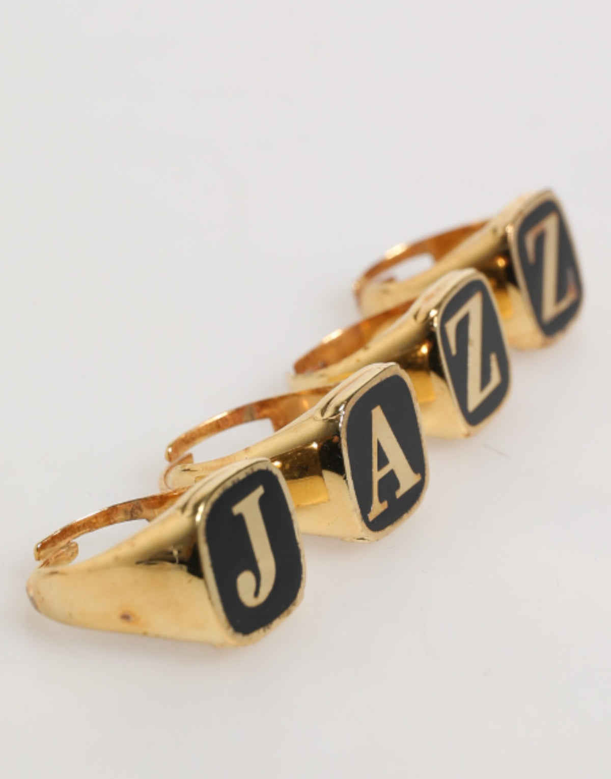 Ensemble de 4 bagues réglables Dolce & Gabbana en laiton doré, avec inscription JAZZ.