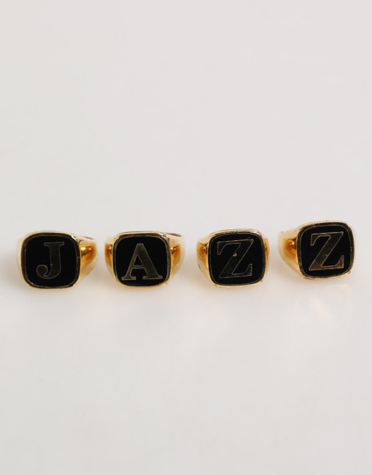 Ensemble de 4 bagues réglables Dolce & Gabbana en laiton doré, avec inscription JAZZ.