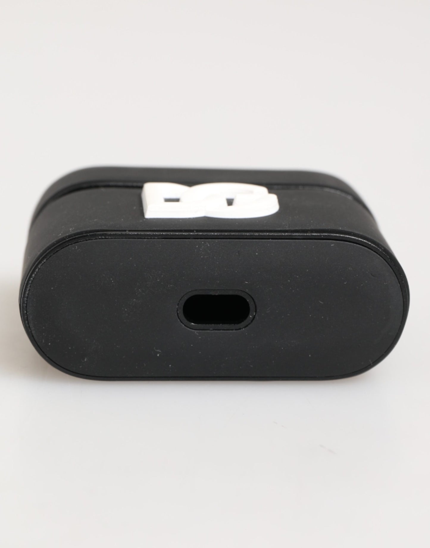 Étui Airpods Dolce &amp; Gabbana en caoutchouc noir et blanc avec logo embossé.