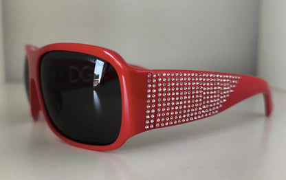Lunettes de soleil Dolce & Gabbana DG4027, monture rouge cristal, verres noirs.